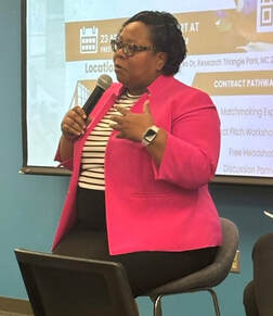 A photo of Dionne McLean speaking on a panel about Contract Pathways for Small Business Owners at Headshots and Business Opportunities.Picture